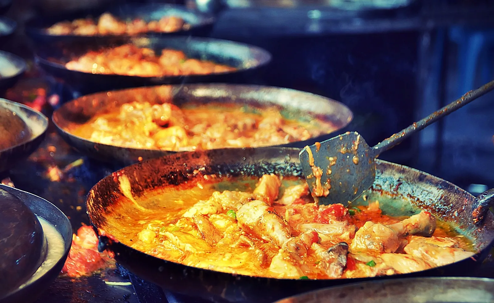Curry being prepared in a traditional karahi